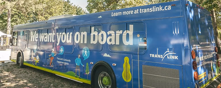 A bus wrapped with a blue advertising message