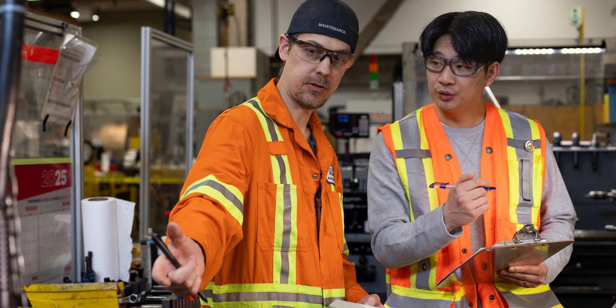 Safety technicians having discussion in high-vis clothing