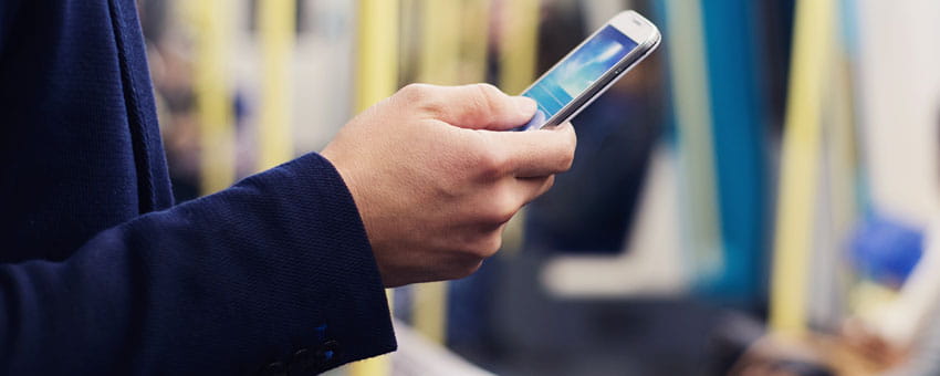 Hand holding mobile device on train