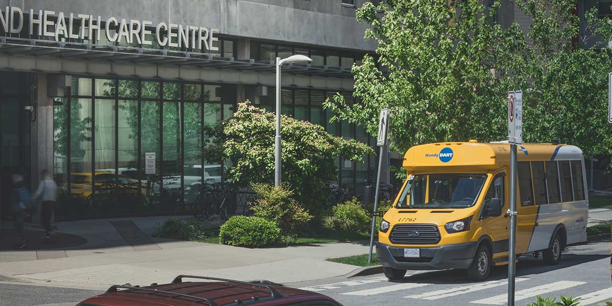 A HandyDART Parked outside a Health Centre waiting for a passenger
