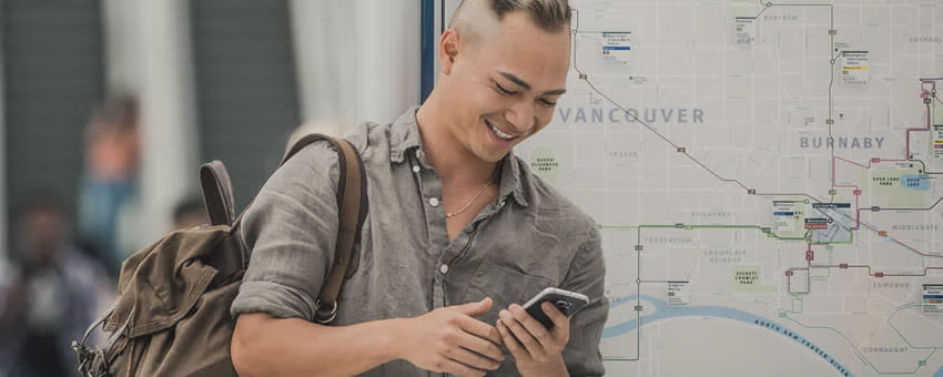 A woman reading the bus stop schedule on the bus stop pole for the #2 Macdonald bus