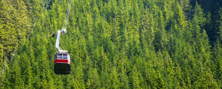 Grouse Mountain Gondola cable-car travelling up the mountain with trees in the background
