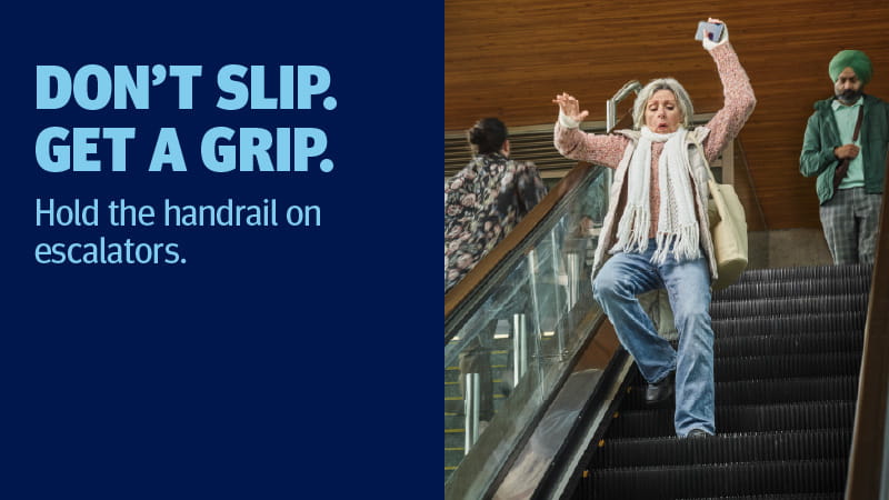 A woman on escalator not holding the handrail and losing balance.