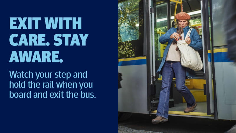 Woman steps off a bus while holding the handrail. Text on the image reads: “EXIT WITH CARE. STAY AWARE. Watch your step and hold the rail when you board and exit the bus.”